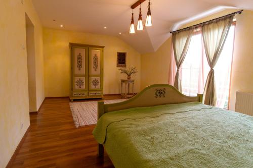 坎皮纳Vila cu Mesteceni的一间卧室设有一张绿色的床和一个窗户。