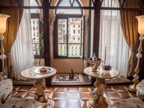 威尼斯EGO' Boutique Hotel - The Silk Road的客厅设有两张桌子和一扇窗户