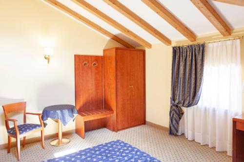 阿科奥利沃酒店的一间卧室配有一张床、一把椅子和一个橱柜
