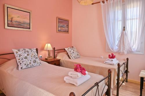 费斯卡尔德宏Villa Ireni Waterfont的配有粉红色墙壁的客房内的两张床