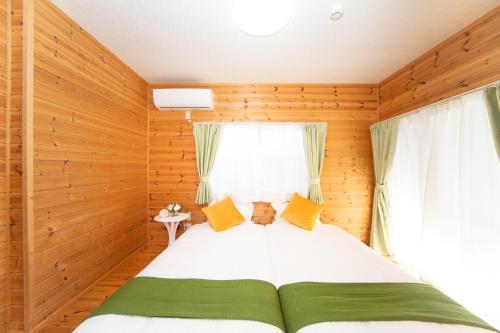 四日市Yokkaichi Motomachi Hotel的木制客房内的一间卧室,配有一张床