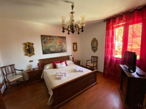 LuniVilla con piscina tra Versilia e Cinque Terre的一间卧室配有一张带红色窗帘的床和电视。