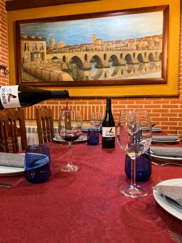 萨莫拉Hotel Puente de Piedra的一张桌子上摆放着一瓶葡萄酒和酒杯