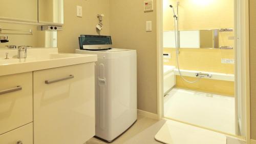 大阪RakutenSTAY x Shamaison Osaka Dekijima - 107的设有带水槽的浴室和冰箱,上面配有电视