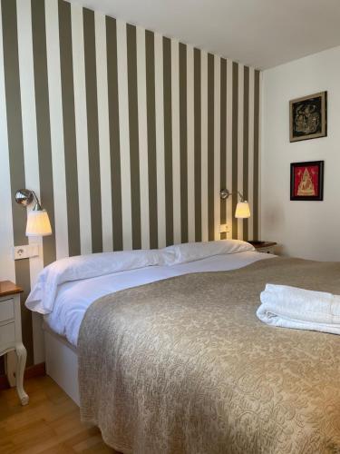 希洪El rincón de Poniente的一间卧室配有一张床和条纹墙