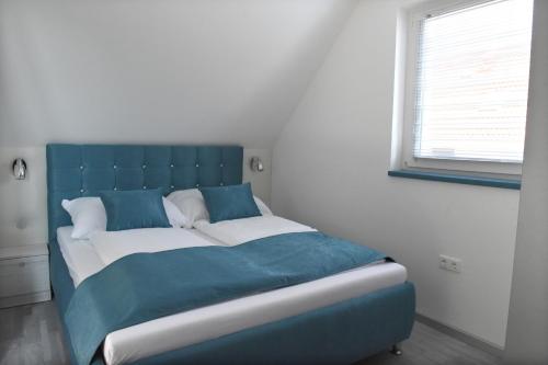 加尔多尼Bell Nyaraló Agárd的一张带蓝色床头板的睡床
