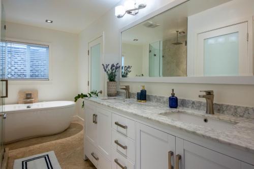 洛杉矶The Green Ginger Guest House的浴室配有盥洗盆、浴缸和镜子