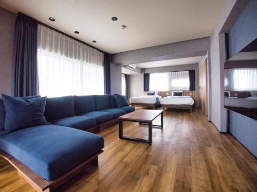 东京ulu Tokyo的一间带蓝色沙发的客厅和一间卧室