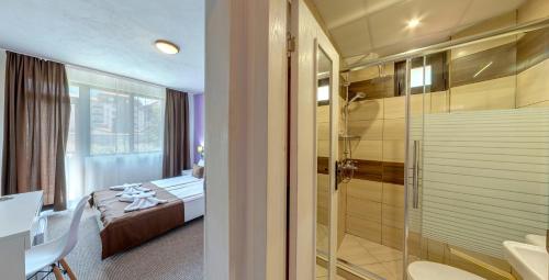 班斯科格拉米酒店的带淋浴的浴室和1间带1张床的卧室