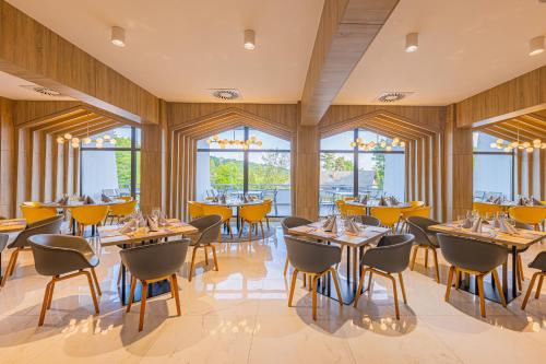 玛塔弗瑞德Avar Hotel的餐厅设有桌椅和窗户。