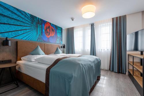 埃森Trip Inn Hotel & Suites Essen的一间酒店客房,配有一张床和一台电视