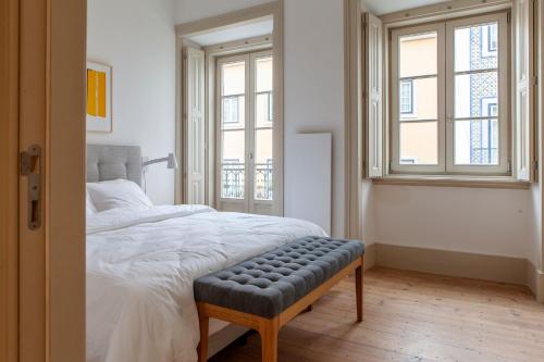里斯本Charming 2BDR Apartment in Lapa by LovelyStay的一间卧室配有一张床,其中配有长凳