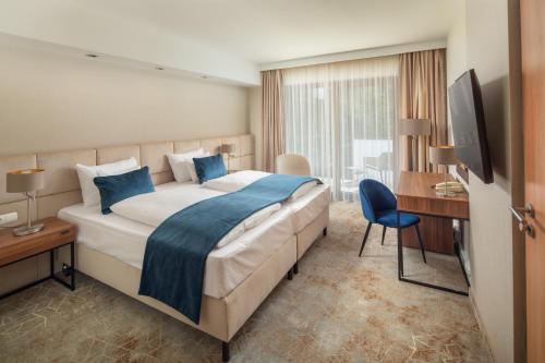 索普隆Fagus Hotel Conference & Spa Superior的酒店客房设有一张大床和一张书桌。