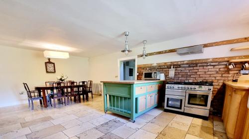 PrestonpansLuxury 5-bed Villa - Winfields House的一间带炉灶的厨房和一间带桌子的用餐室