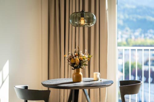 弗莱堡Black F Tower - Serviced Apartments的花瓶和窗户的桌子
