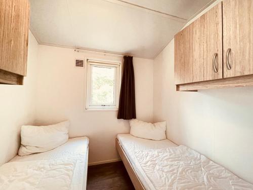 乌曼茨Regenbogen Suhrendorf的小房间设有两张床和窗户