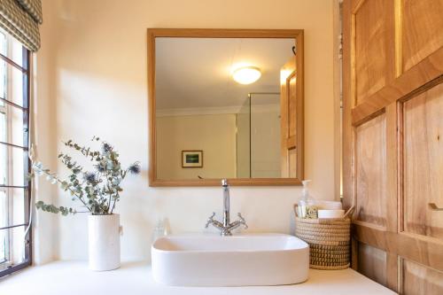 格拉夫-里内特Sunbird Cottage的一间带水槽和镜子的浴室
