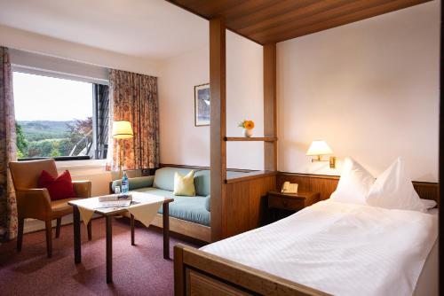 施马伦贝格斯托曼酒店的酒店客房配有床、沙发和桌子。