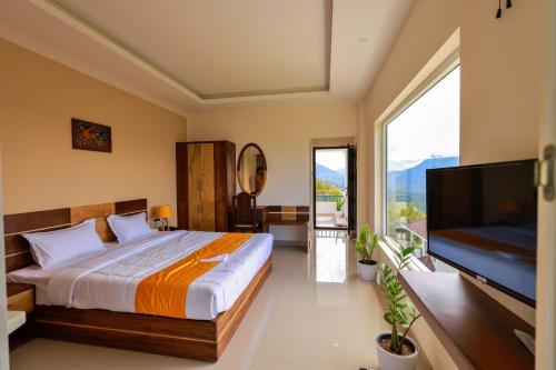 钦纳卡纳The Windy Mist Resort Munnar的一间卧室配有一张大床和一台平面电视