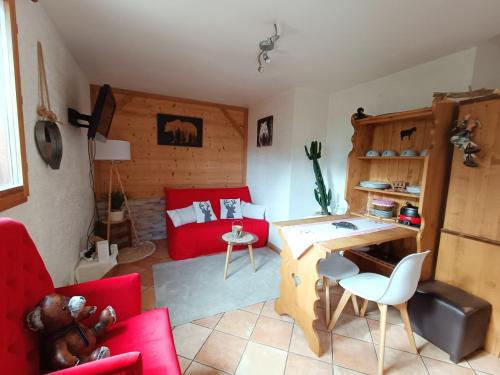 AigueblancheAppartement avec terrasse et parking Privé的客厅配有红色家具和红色沙发