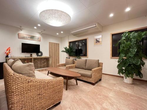 白滨白浜の宿　 蘭的客厅配有椅子、桌子和电视