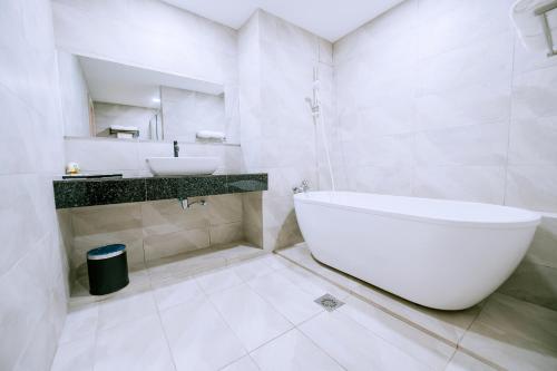 瓜埠The Concept Hotel Langkawi的白色的浴室设有浴缸和水槽。