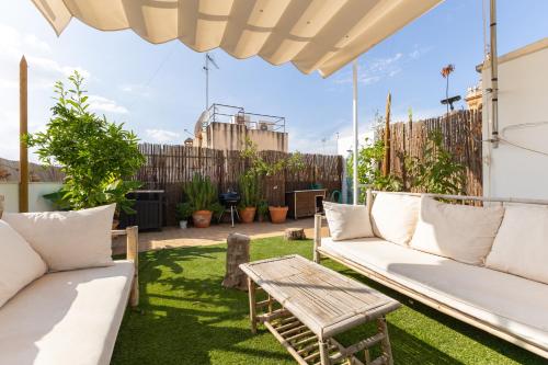 塞维利亚Tentudia Charming Apartments with Private Roof-Top or Patio in San Bernardo By Oui Seville的庭院配有白色的沙发和桌子