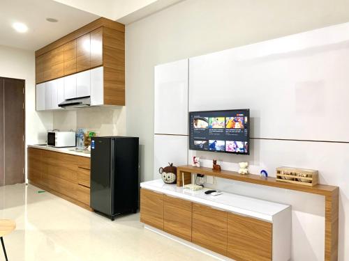 名古屋Family room at Apartemen Formosa Residence Nagoya Batam by Wiwi的厨房配有黑色冰箱和木制橱柜。