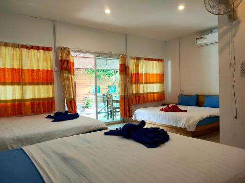 高龙撒冷岛甜蜜时光旅馆的一间卧室设有两张床和窗户。