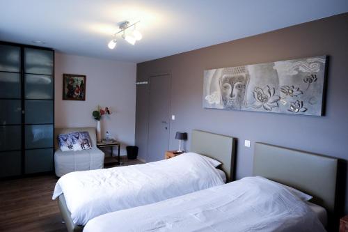 根特蒙塔里住宿加早餐旅馆的一间卧室设有两张床,墙上挂着一幅画