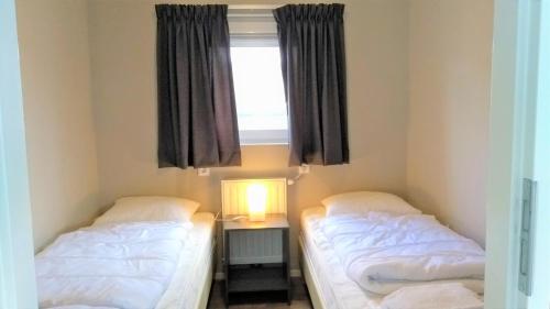 克诺克－海斯特Luxe cottage met fietsen, airco & infrarood cabine的带窗户的客房内的两张床