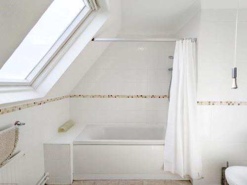 博格诺里吉斯11 Shorecroft, Aldwick的带浴缸的浴室和窗户。