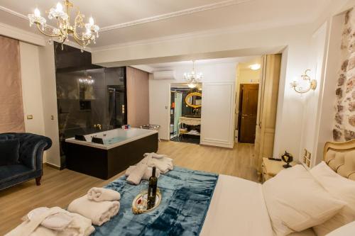 纳弗帕克托斯Vip Lepanto Port Suites的一间带浴缸的浴室、一张床和一间房间