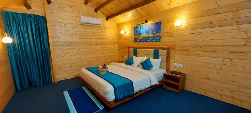 马尔万Parisa beach resort Tarkarli Bhogwe的木制客房内的一间卧室,配有一张床