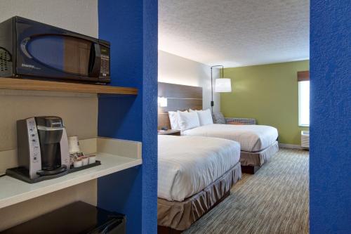 ObetzHoliday Inn Express Columbus South - Obetz, an IHG Hotel的酒店客房设有两张床和一台墙上的电视。