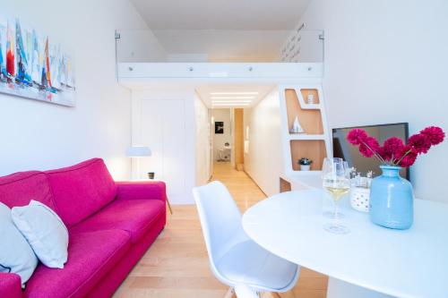 波托菲诺Wanderlust by PortofinoHomes的客厅配有粉红色的沙发和白色的桌子