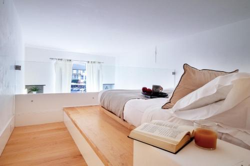波托菲诺Wanderlust by PortofinoHomes的白色卧室配有一张床和一张带键盘的书桌