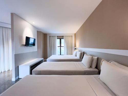 纳塔尔普拉亚玛纳塔尔酒店及会议中心的酒店客房,设有两张床和一张沙发