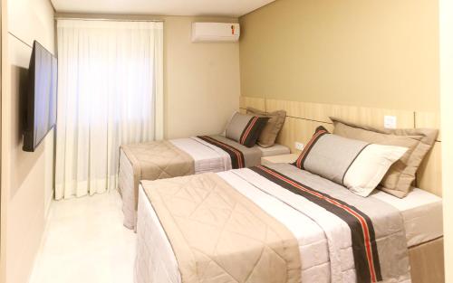 伊瓜苏Apartamento completo - Vila A的酒店客房设有两张床和电视。