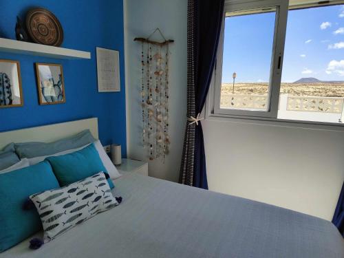 科拉雷侯CorralejoDunas piscinas wifi tenis bicicletas的一间卧室配有一张床,享有海滩美景