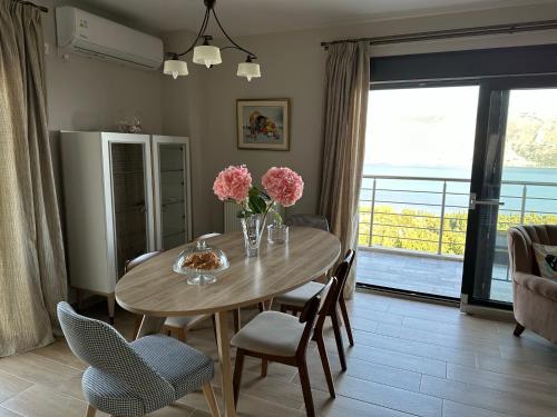 里科索翁Villa Argyro的用餐室配有带鲜花和椅子的桌子