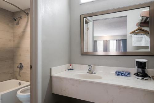 布莱斯维尔Americas Best Value Inn and Suites Blytheville的一间带水槽、镜子和卫生间的浴室