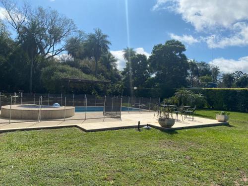 科连特斯casa-quinta cerca de corrientes y santa ana的公园设有游泳池、椅子和桌子
