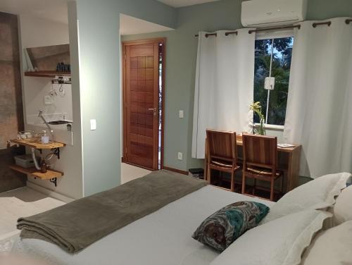 尼泰罗伊Casa da Lu Itacoatiara -Suite Alto Mourão的一间卧室配有一张床、一张书桌和一个窗户。