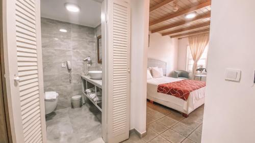 博德鲁姆Museum Resort Spa的一间卧室配有一张床,浴室设有淋浴。