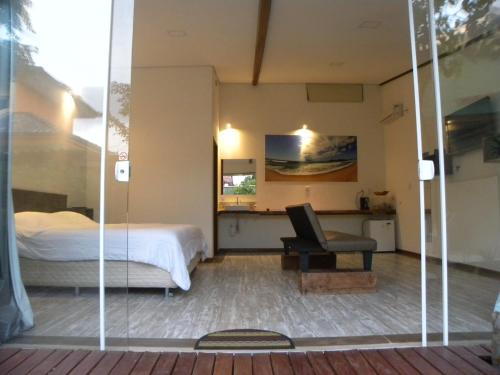 弗洛里亚诺波利斯Green Lodge Eco Life Hotel的一间卧室配有一张床、一张桌子和一把椅子