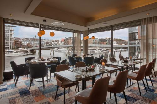 特隆赫姆斯堪迪克尼德伦酒店的餐厅设有桌椅,享有海港的景色