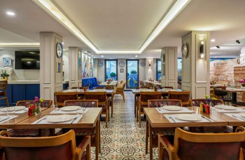 伊斯坦布尔Royan Hotel Hagia Sophia, a member of Radisson Individuals的配有木桌和椅子的餐厅