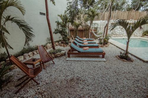 图卢姆Aldea San Lam - Oasis Of Tulum的一个带躺椅的庭院和一个游泳池