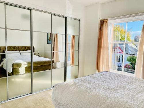 珀斯Lovely 2 bed specious flat with indoor fire place的一间卧室设有一张床和一个大窗户